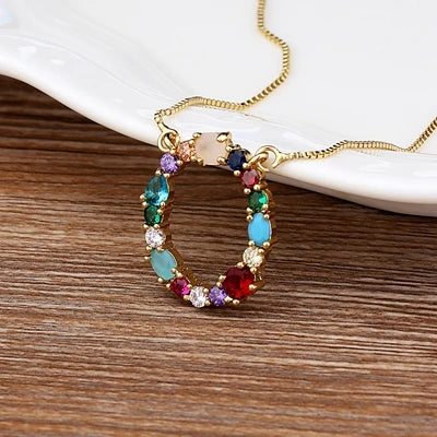 Collar con iniciales y piedras preciosas doradas de 18 quilates