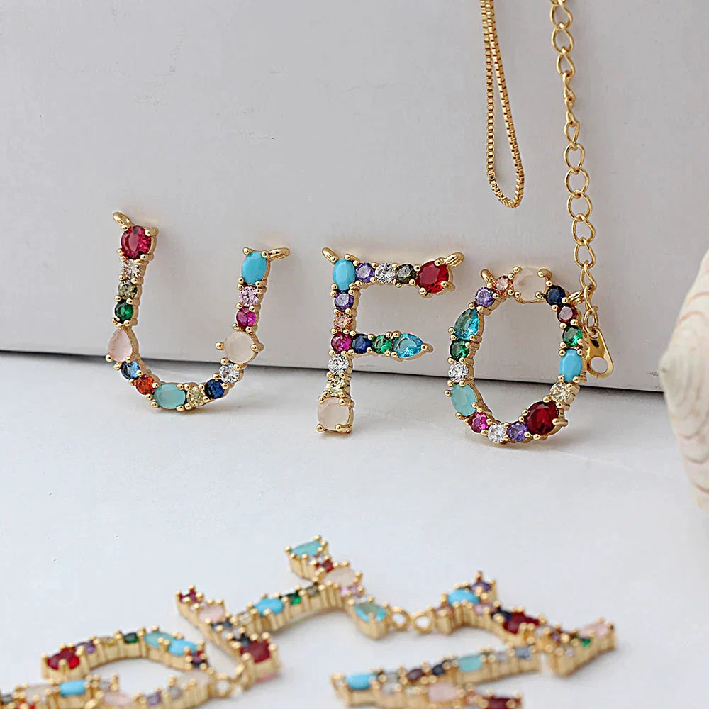 Collar con iniciales y piedras preciosas doradas de 18 quilates