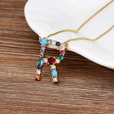 Collar con iniciales y piedras preciosas doradas de 18 quilates