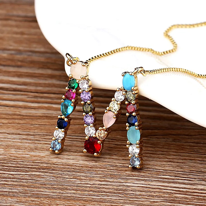 Collar con iniciales y piedras preciosas doradas de 18 quilates