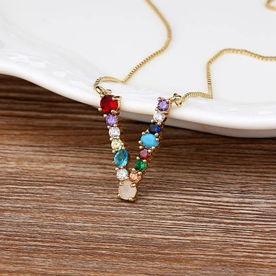 Collar con iniciales y piedras preciosas doradas de 18 quilates