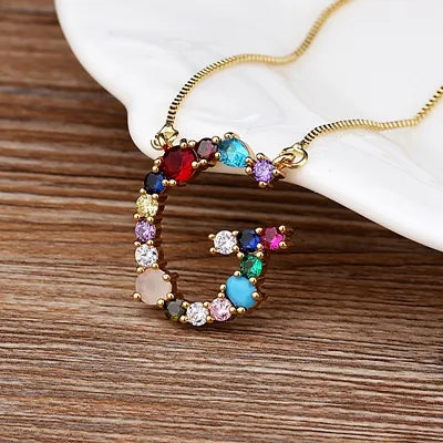Collar con iniciales y piedras preciosas doradas de 18 quilates