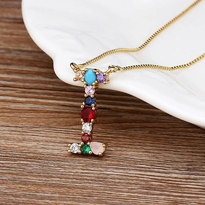 Collar con iniciales y piedras preciosas doradas de 18 quilates