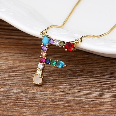 Collar con iniciales y piedras preciosas doradas de 18 quilates