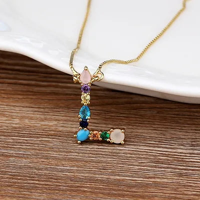 Collar con iniciales y piedras preciosas doradas de 18 quilates