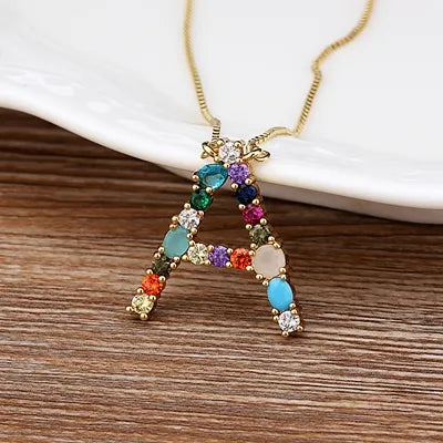 Collar con iniciales y piedras preciosas doradas de 18 quilates