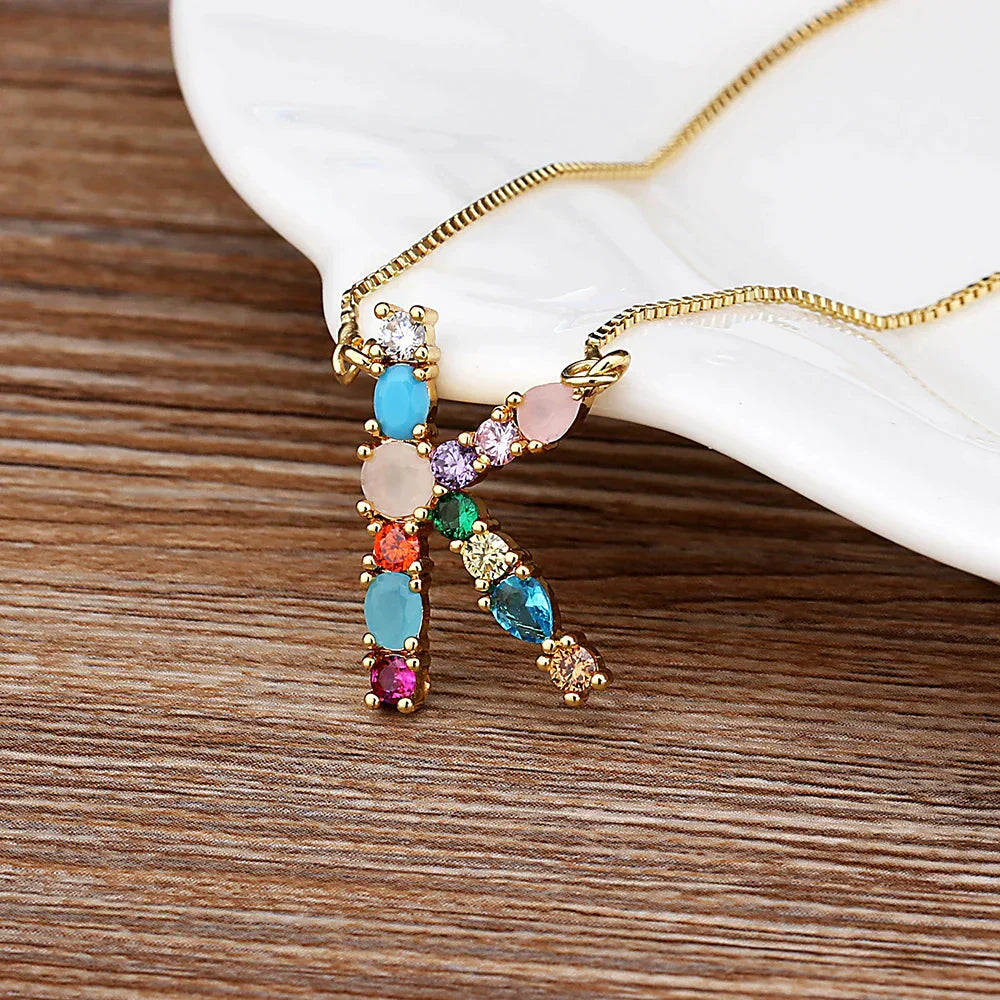 Collar con iniciales y piedras preciosas doradas de 18 quilates