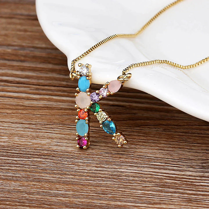 Collar con iniciales y piedras preciosas doradas de 18 quilates