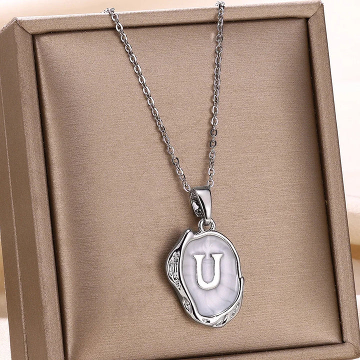 Collar océano con iniciales dorado de 18 quilates en el fondo marino